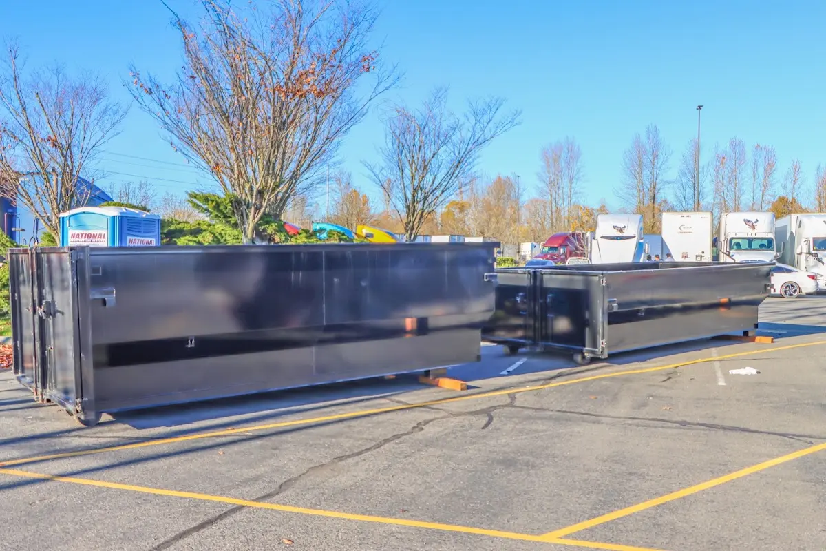 Professional dumpster rental service with roll-off container on residential driveway in Atlas